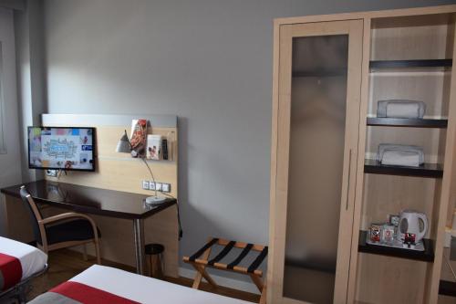 a bedroom with a desk and a computer in a room at Hotel Holiday Inn Express Madrid-Rivas by IHG in Rivas-Vaciamadrid