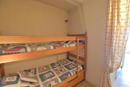 um quarto com 2 beliches num quarto em Studio cabine résidence avec piscine et garage le Lagon bleu em Le Grau-du-Roi