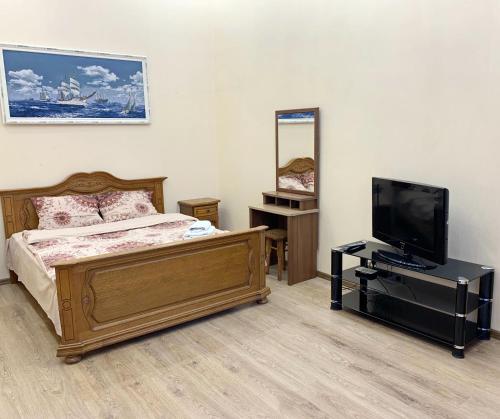 Un dormitorio con una cama y un televisor de pantalla plana. en Lanzheronovskaya street, en Odessa