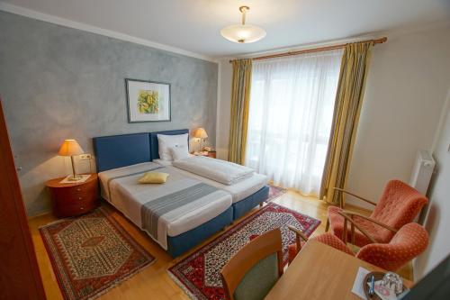 een slaapkamer met een bed en een tafel en stoelen bij Pension Christina in Weiz
