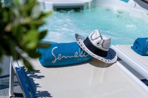 a hat sitting on the side of a swimming pool at Semeli Hotel Mykonos in Mýkonos City