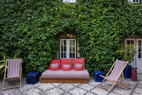 a red couch sitting in front of a garden at York House Lisboa Hotel in Lisbon