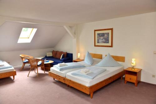 een slaapkamer met een bed, een bank en een tafel bij Pension Bloo Tomato in Zittau