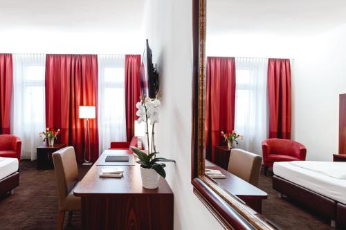 een hotelkamer met een tafel en een spiegel bij Hotel Allegro Wien in Wenen