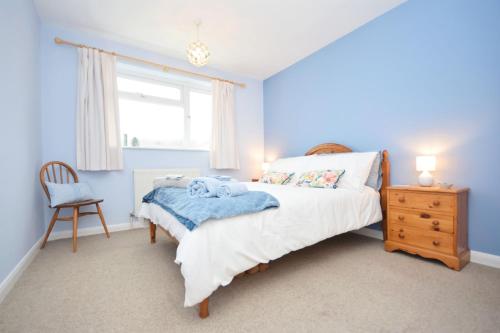 um quarto com uma cama, uma cadeira e uma janela em Orchard Mews , Barnham em Barnham