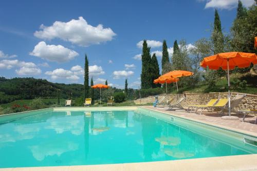 a swimming pool with orange umbrellas and chairs at Iris in Poggibonsi