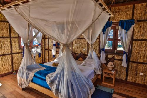a bedroom with a canopy bed with mosquito nets at CAP KIMONY in Morondava
