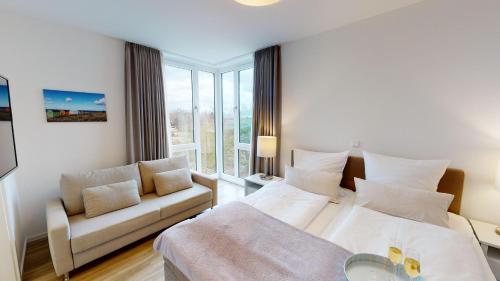 a hotel room with two beds and a couch at Südkap E-04 in Pelzerhaken