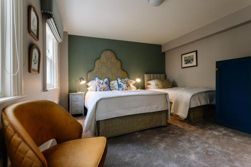 a bedroom with two beds and a chair at Ralph's in Moira