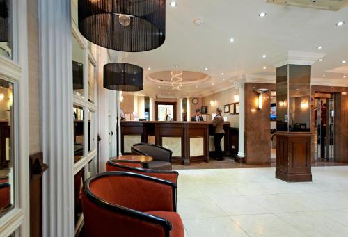 a man standing at a bar in a hotel lobby at Royal Eagle Hotel in London