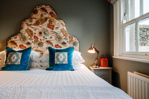 a bedroom with a large bed with blue pillows at Ralph's in Moira