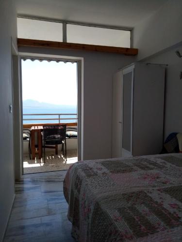 a bedroom with a bed and a view of the ocean at Atlas Apartment with Private Beach and SeaView in Loutraki