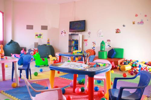 a room filled with lots of toys and tables and chairs at San Agustin Paracas in Paracas