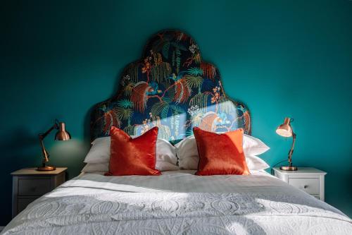 a blue bedroom with a large bed with red pillows at Ralph's in Moira