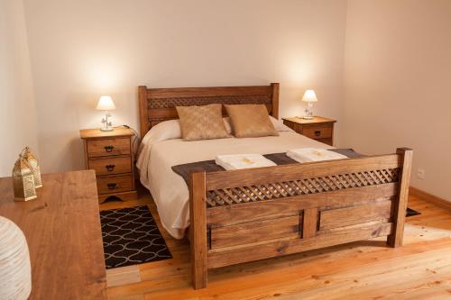 a bedroom with a large wooden bed with two night stands at Quinta do Pico in Ponta Delgada