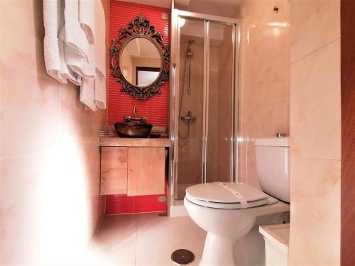 a bathroom with a toilet and a shower and a mirror at Casa da Avó in Elvas