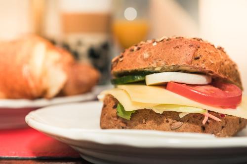 a sandwich on a white plate on a table at Hotel Allegra in Heinsberg