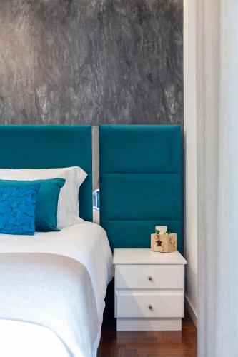 a bedroom with a blue headboard and a bed with a night stand at Casa das Carpas in Vizela