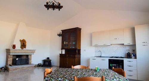 una cucina con tavolo e una cucina con camino di Alba Sarda Residence a Iglesias