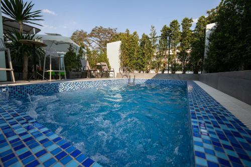 a swimming pool with blue tiles in a backyard at Viryla Boutique Hotel in Vientiane
