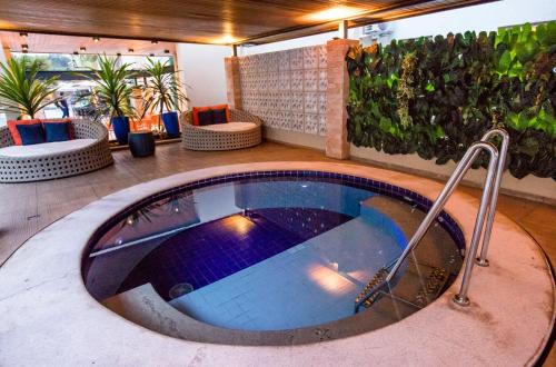 a hot tub in a room with plants at Hotel Morada do Sol in Caldas Novas