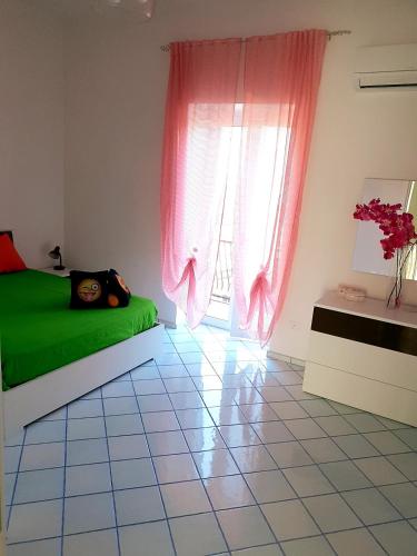 a bedroom with a green bed and a window at casa vacanza cilento PARDALIS in Agropoli