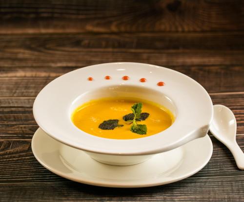 a bowl of soup on a plate with a spoon at Viryla Boutique Hotel in Vientiane