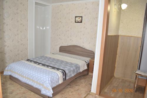 una piccola camera da letto con un letto in una stanza di 1 комнатные апартаменты на Абая 134 a Kökşetaw