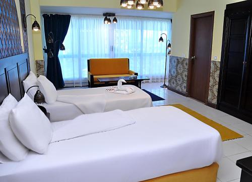 New Star Zamalek Hotel في القاهرة: غرفة فندقية بسريرين واريكة