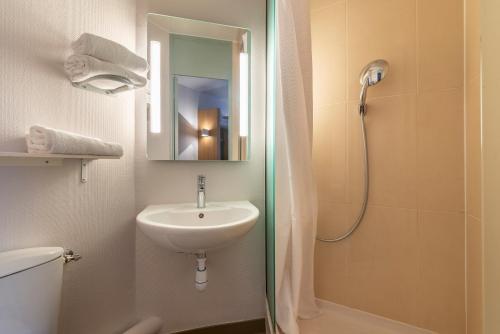 a bathroom with a sink and a shower with a mirror at B&B HOTEL Valence Sud in Valence