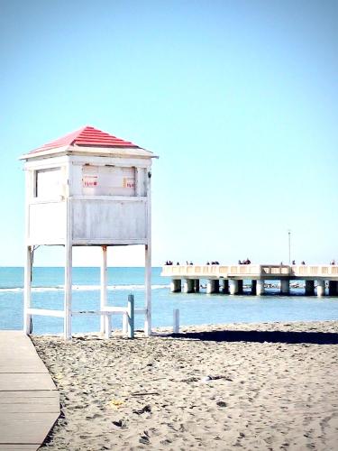 a life guard shack on the beach with a pier at a un passo dal mare in Lido di Ostia