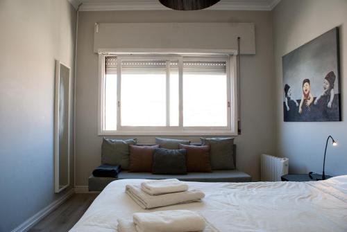 um quarto com uma cama com duas toalhas em Baixa24 - Bolhão Apt with Sunset Rooftop no Porto
