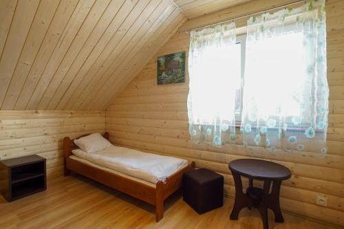 a small room with a bed and a window at Górska Chata u Kota in Huta Szklana