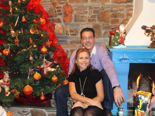 a man and a woman sitting next to a christmas tree at Galaxa Mansion in Galaxidhion