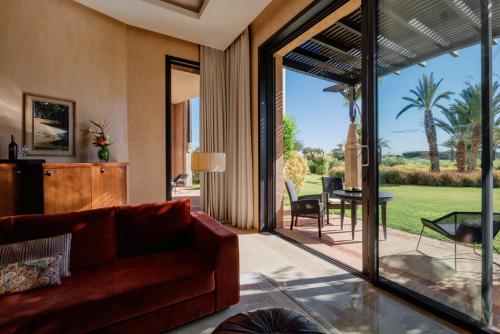 a living room with a red couch and a sliding glass door at Fairmont Royal Palm Marrakech in Marrakech