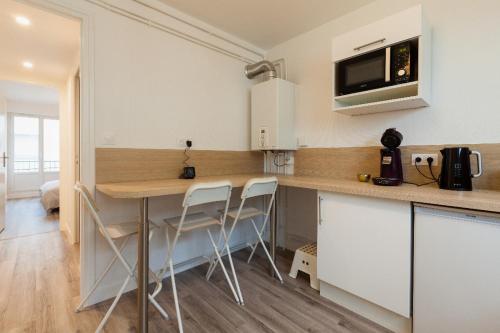 una cucina con un tavolo e sedie in una stanza di Appart Center Bara a Brest