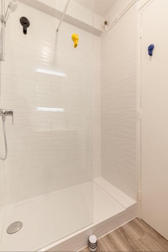 La salle de bains est pourvue d'une douche blanche avec une porte en verre. dans l'établissement Appart Center Bara, à Brest