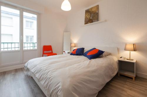 una camera da letto con un letto grande e una sedia rossa di Appart Center Bara a Brest