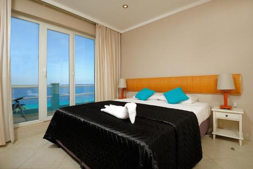 Oceanfront Tarpon at Den Laman في كراليندايك: غرفة نوم عليها سرير وفوط