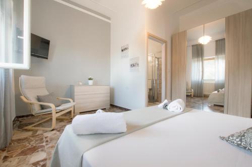 1 dormitorio con 1 cama blanca y 1 silla en Salento Inside, en Morciano di Leuca