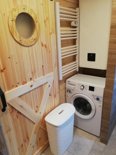 a small bathroom with a washing machine and a washer at Domki nad jeziorem - Zalesie 7D in Zalesie