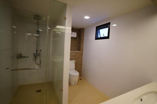 a bathroom with a shower and a toilet and a television at Treescape Resort Chiangmai in Chiang Mai