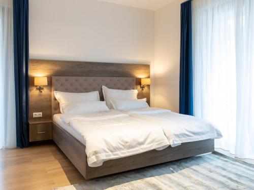 ein Schlafzimmer mit einem großen Bett mit weißer Bettwäsche und Kissen in der Unterkunft Premium Green Apartments Vienna in Wien
