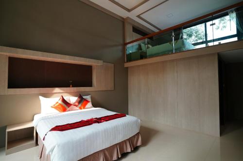 a bedroom with a large white bed with red pillows at Treescape Resort Chiangmai in Chiang Mai