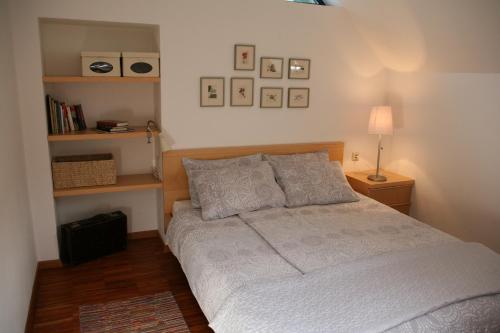 ein Schlafzimmer mit einem Bett, einer Lampe und Regalen in der Unterkunft Apartments Cvetje v Jeseni in Škofja Loka