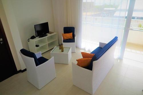 a living room with two chairs and a television at Tree Bies Resort - Oficial in Subaúma