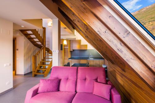a living room with a pink couch in a house at Apartaments Trainera in Esterri d'Àneu
