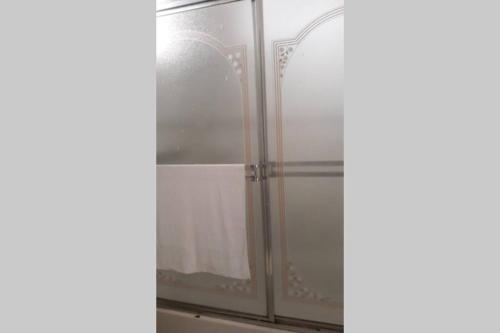 y baño con ducha y puerta de cristal. en Amplio y acogedor apartamento en Santiago de los Caballeros