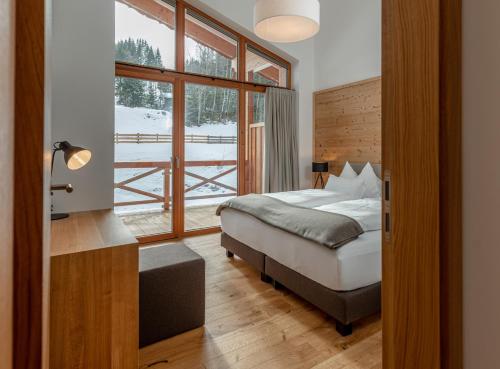 a bedroom with a bed and a large window at Skylodge Alpine Homes in Haus im Ennstal
