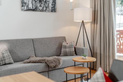 a living room with a gray couch and a table at Skylodge Alpine Homes in Haus im Ennstal